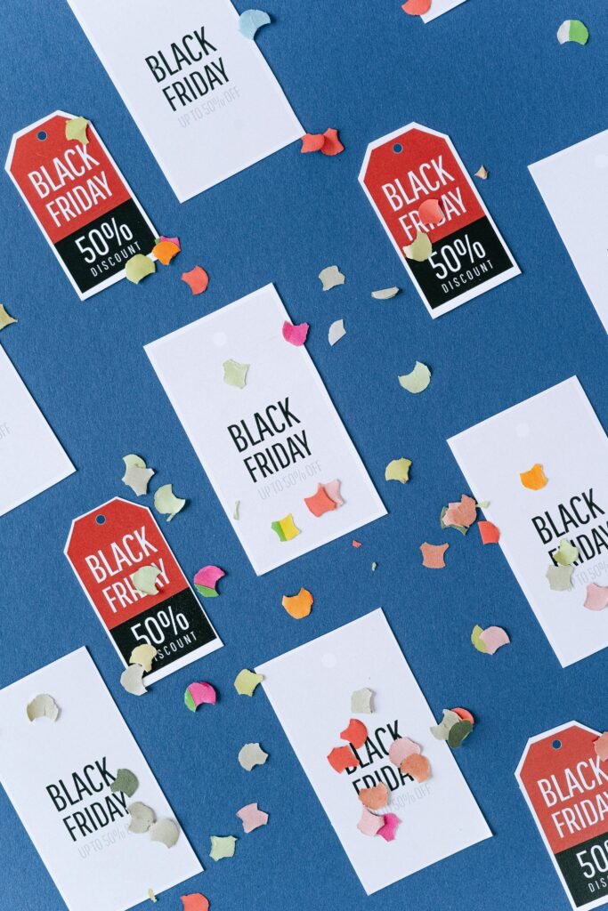 Creative arrangement of Black Friday discount tags with colorful confetti on a blue backdrop, perfect for sales promotion.